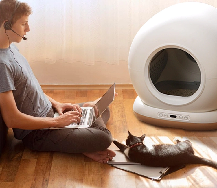 Man working from home with cat beside a Smart Pet Supplies automatic litter box, ideal pet product for modern pet brands.