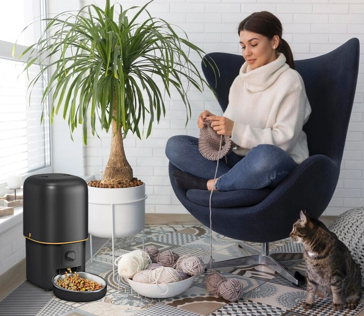 Woman knitting at home with cat and Smart Pet Supplies automatic pet feeder, innovative pet product for growing pet brands.