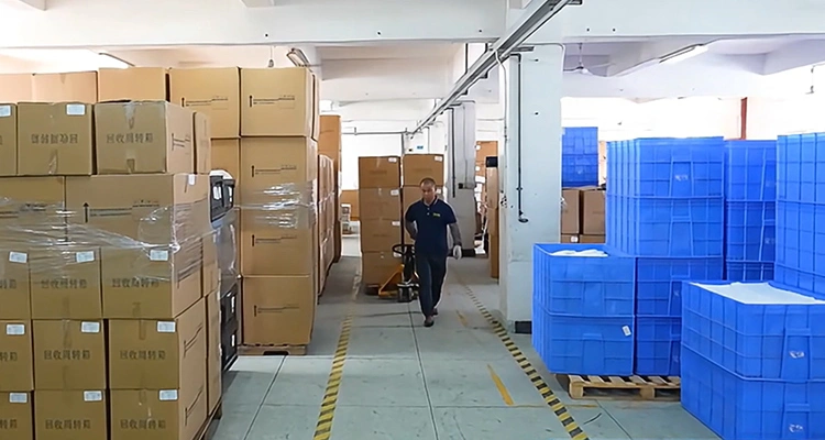 A warehouse worker moving pallets of packaged goods with a pallet jack, depicting efficient packaging and shipping to minimize automatic cat feeder sourcing pitfalls.