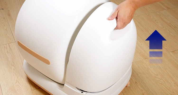A hand holding the top of a Petrust CB002 automatic litter box, showing how to open it for cleaning and demonstrating one of the key automatic litter box cleaning tips.