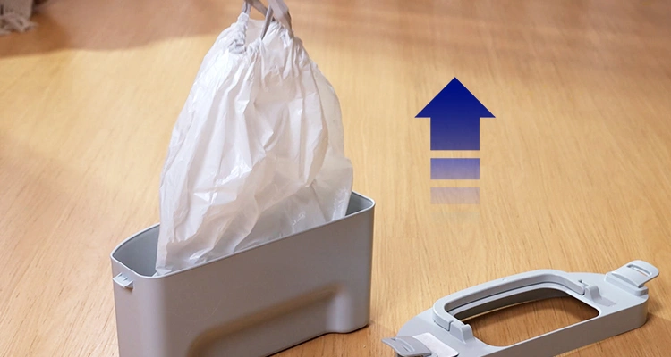 A close-up of the waste drawer from a Petrust CB002 automatic litter box with a full bag of waste being lifted out, demonstrating automatic litter box cleaning tips for easy and mess-free disposal.