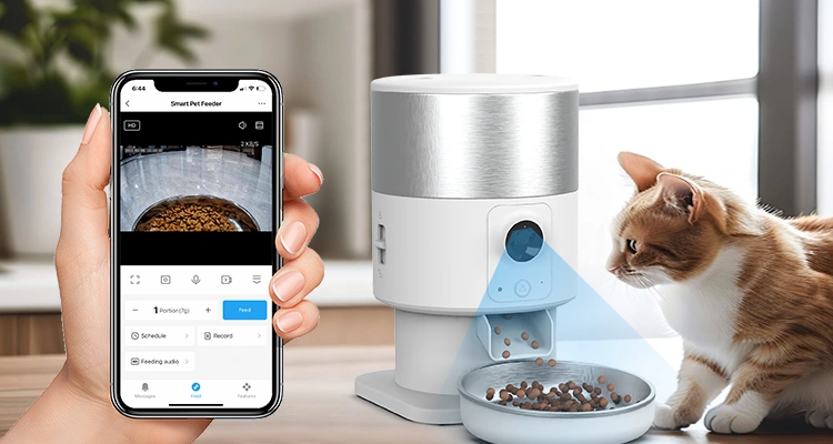 A hand holding a smartphone showing an app interface for a smart pet feeder, next to a cat watching food dispense from a portion control automatic cat feeder OEM with a camera.