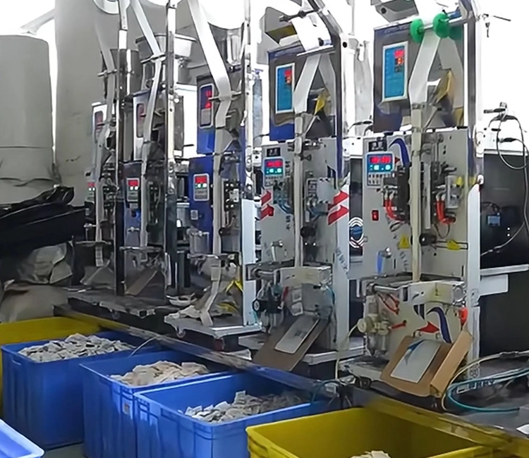 A row of automated vertical packaging machines in a factory, filling and sealing bags of filter components, showing the manufacturing scale of a smart cat water fountain manufacturer in China.