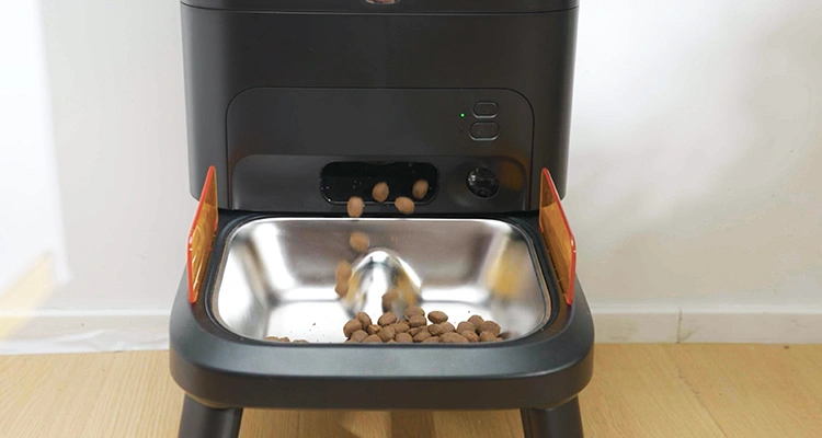 Kibble dispensing into a slow-feeder style stainless steel bowl from a smart automatic feeder for large dogs.