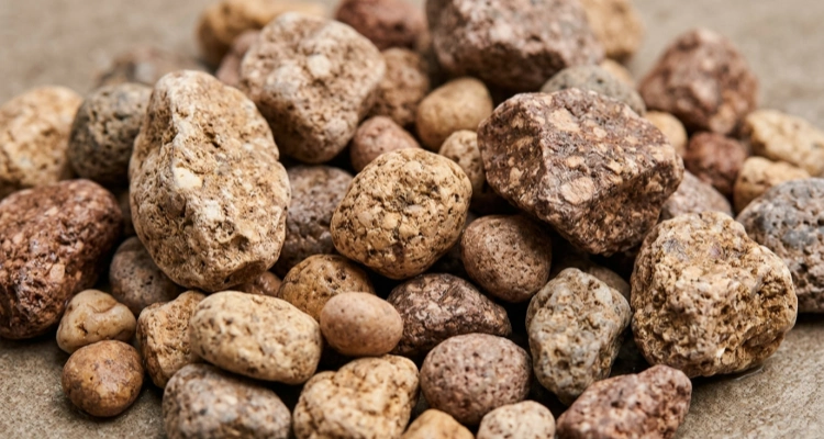 Pile of natural brown Maifan mineral stones used as filter media in pet water fountain filters to release essential minerals and balance pH levels.