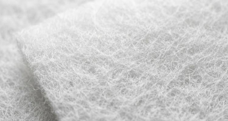 Texture shot of white high-density microporous cotton used in pet water fountain filters to trap pet hair, debris, and sediment.